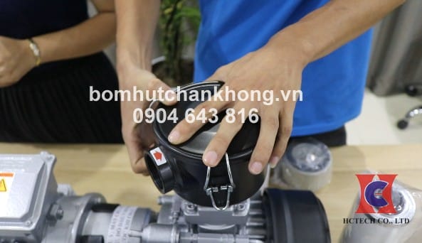 Tháo bỏ lẫy giữ nắp lọc bơm chân không