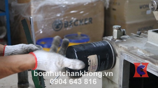 Vặn ren và tháo lọc nhớt ra khỏi bơm chân không
